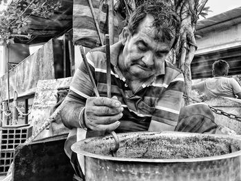 Vendor carrying utensil with serving tongs at market stall