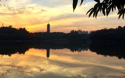 Reflection of trees in water at sunset