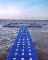 Woman standing on pier over sea