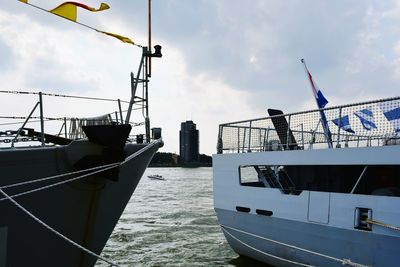 Boats moored at harbor against sky