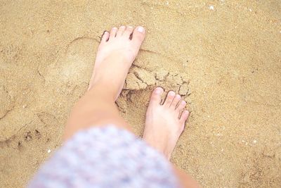 Low section of girl standing at beach