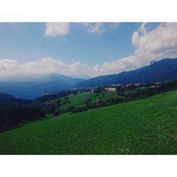 Scenic view of grassy field against cloudy sky