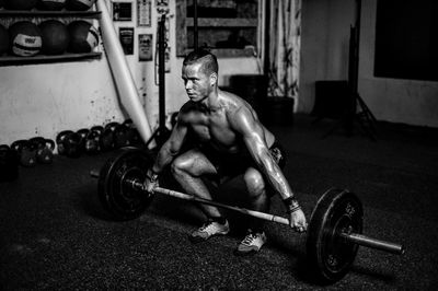 Portrait of man lifting barbell in gym