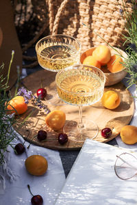 Summer picnic on a lavender field with champagne glasses, croissants, apricots and cherry berries