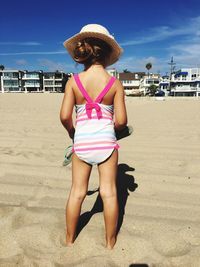 Rear view of girl wearing bikini at beach during sunny day