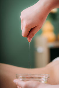 Massage oil. therapist pouring aromatic massage oil onto womans back