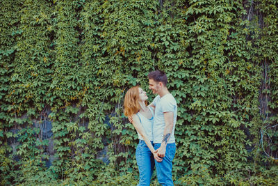 Man and woman standing by plants