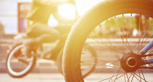 Close-up of bicycle wheel on street during sunny day