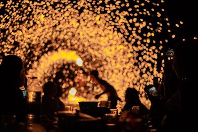 People watching fire dancer at night