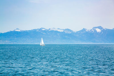 Boat on sea against mountains
