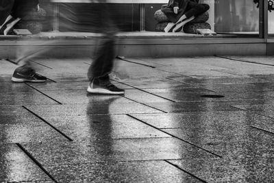 Low section of people walking on footpath in city