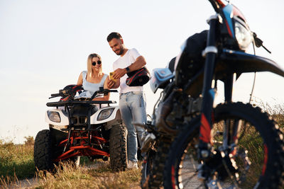 Low angle view of man riding motorcycle on field