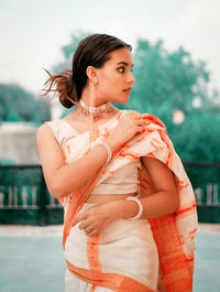 Young woman wearing sari looking away while standing outdoors