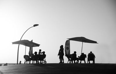 Silhouette of people relaxing at beach