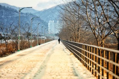 Snow covered footbridge against sky