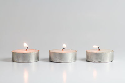 Close-up of burning candle against black background