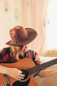 Midsection of woman playing guitar