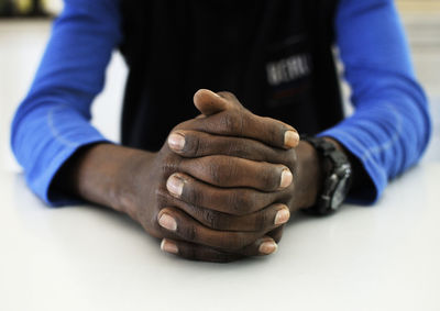 Midsection of man sitting on table