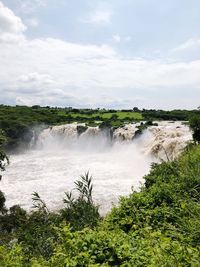 Scenic view of waterfall against sky