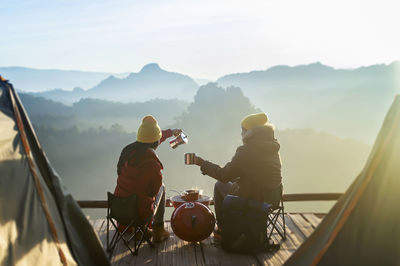 Men standing on mountain against sky