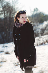 Portrait of young woman standing in snow