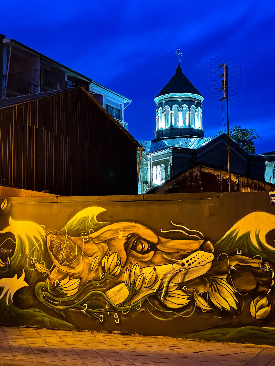 GRAFFITI ON ILLUMINATED BUILDING AT NIGHT