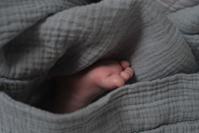 Close-up of baby hand on bed