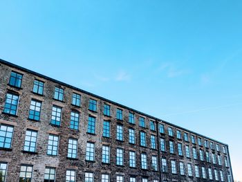 Low angle view of modern building against blue sky