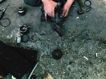 Cropped hands of mechanic working on road