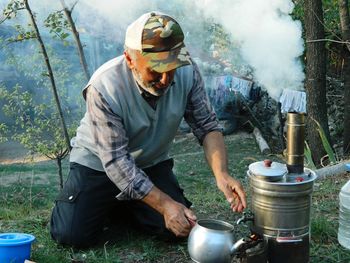 Mature man preparing food at campsite