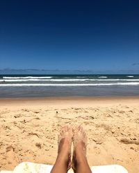 Low section of woman relaxing on beach