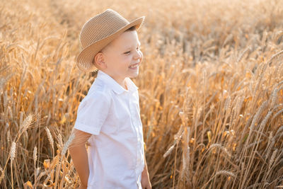 Side view of girl standing on hay