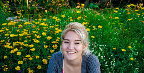 Portrait of smiling woman against yellow flower