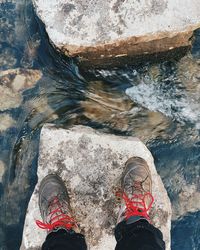 Low section of man standing on rock