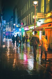 People walking in illuminated city at night