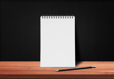 Close-up of pen on table against black background