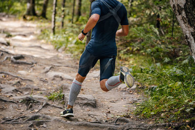 Low section of man walking on field