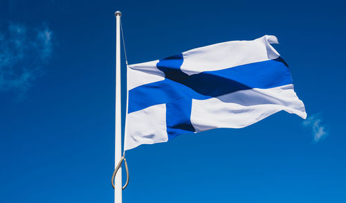 Low angle view of flag against blue sky