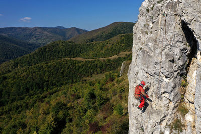 Aerial view of mountain rescuer doing rescue operations hanging on a rope