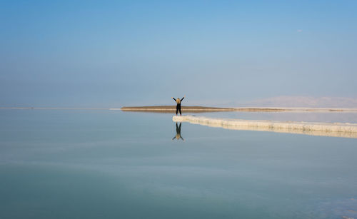 Woman in sea against clear sky