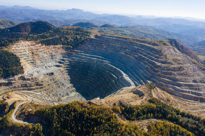 Flying above an open pit mine, copper excavation in rosia poieni, romania. aerial drone view