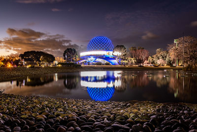 Scenic view of lake against cloudy sky at night