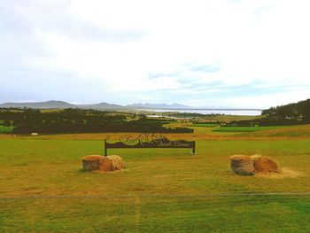 Hay bales on field against sky