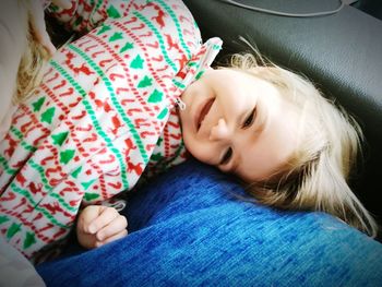 Close-up of baby girl lying down on sofa