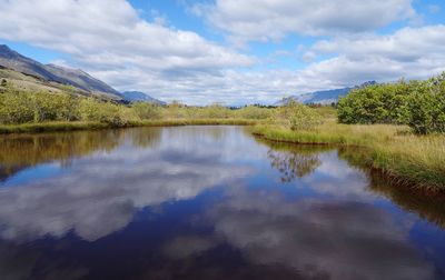 Scenic view of lake and mountains against sky