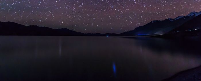 Scenic view of lake against sky at night