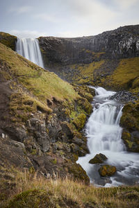 Scenic view of waterfall against sky