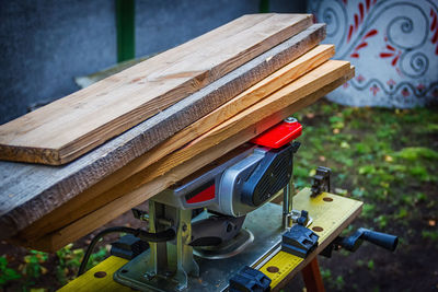 High angle view of stacked planks on electroplane in yard