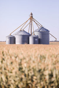 Factory on field against clear sky