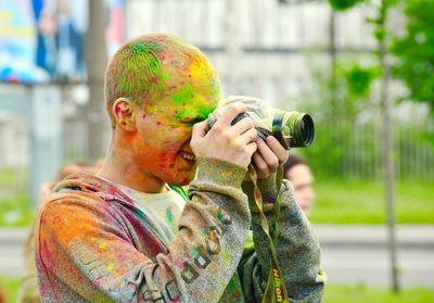 Man with powdered paint while photographing during holi